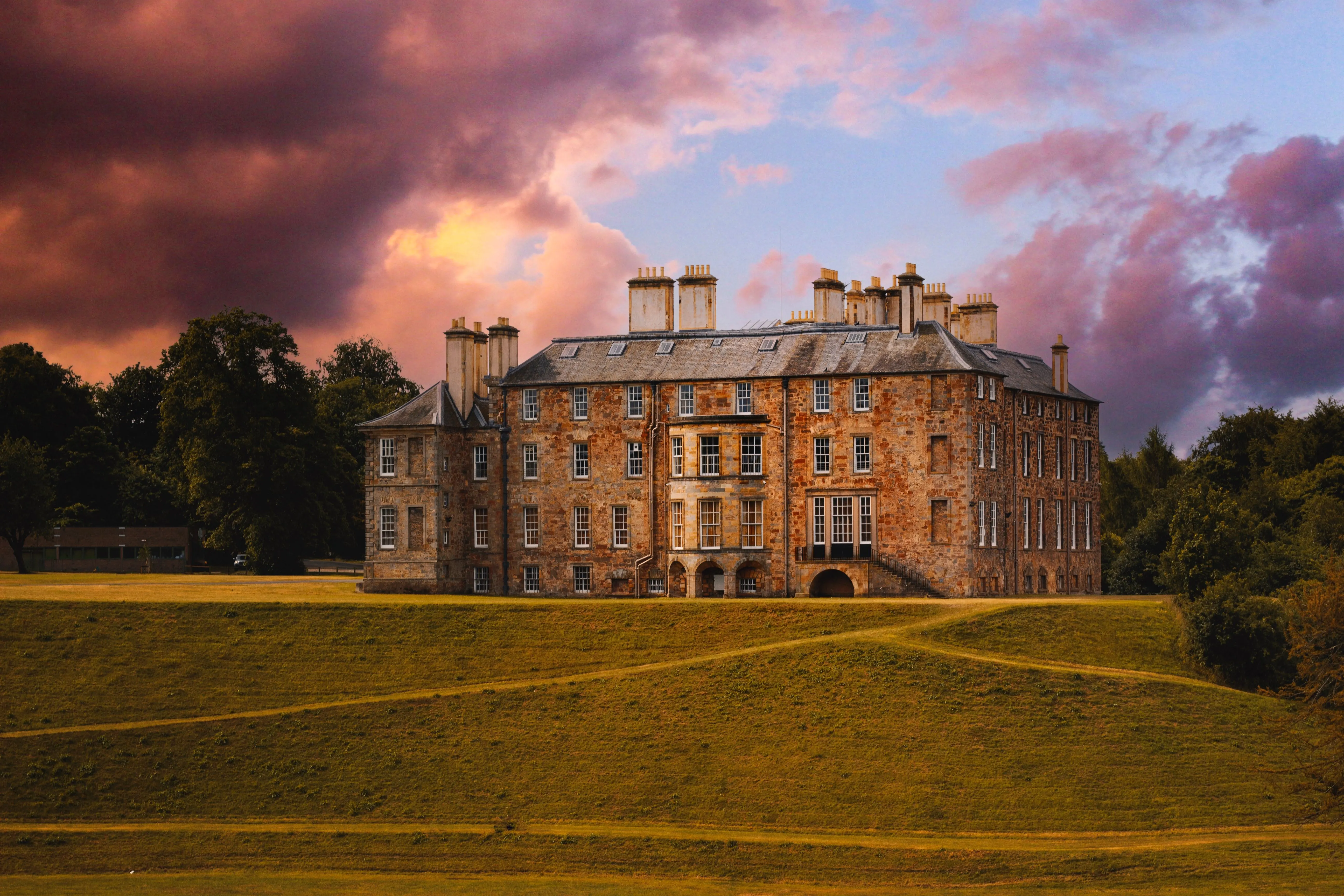 Eldermere Hall at golden hour, seen across its lawns